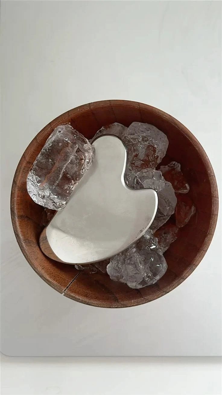 Gua sha-verktyg i en skål med is
